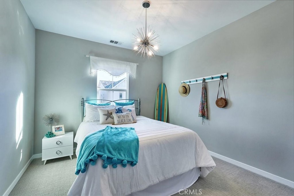 944 Sunlit Lane Costa Mesa, CA 92626 - Photo 45 of 71 a bedroom with a bed and a chandelier