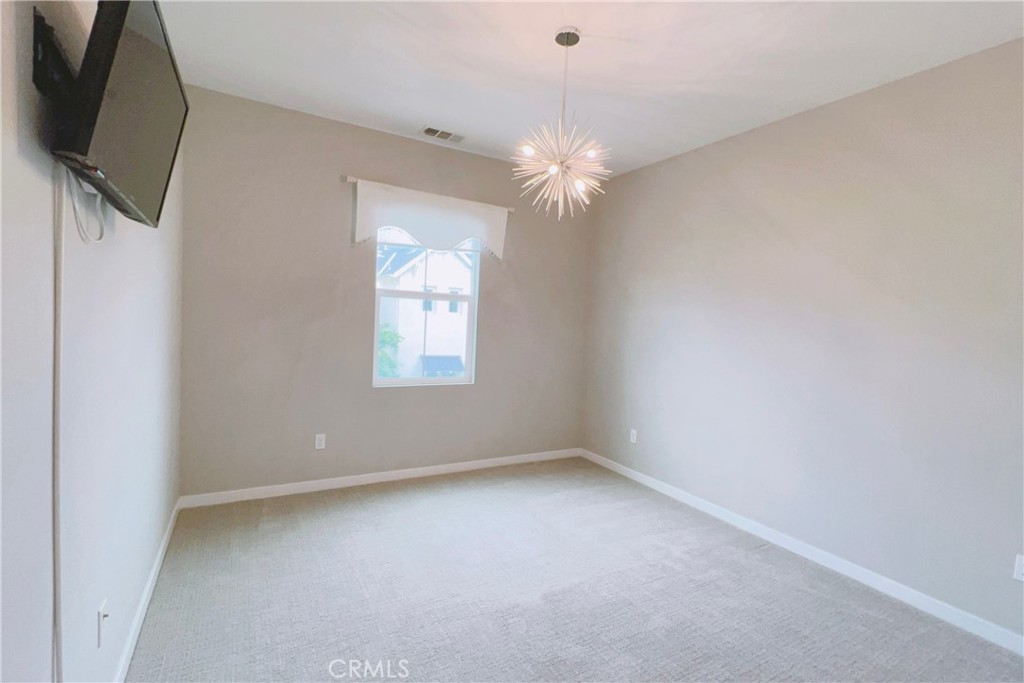 944 Sunlit Lane Costa Mesa, CA 92626 - Photo 46 of 71 an empty room with chandelier fan and windows