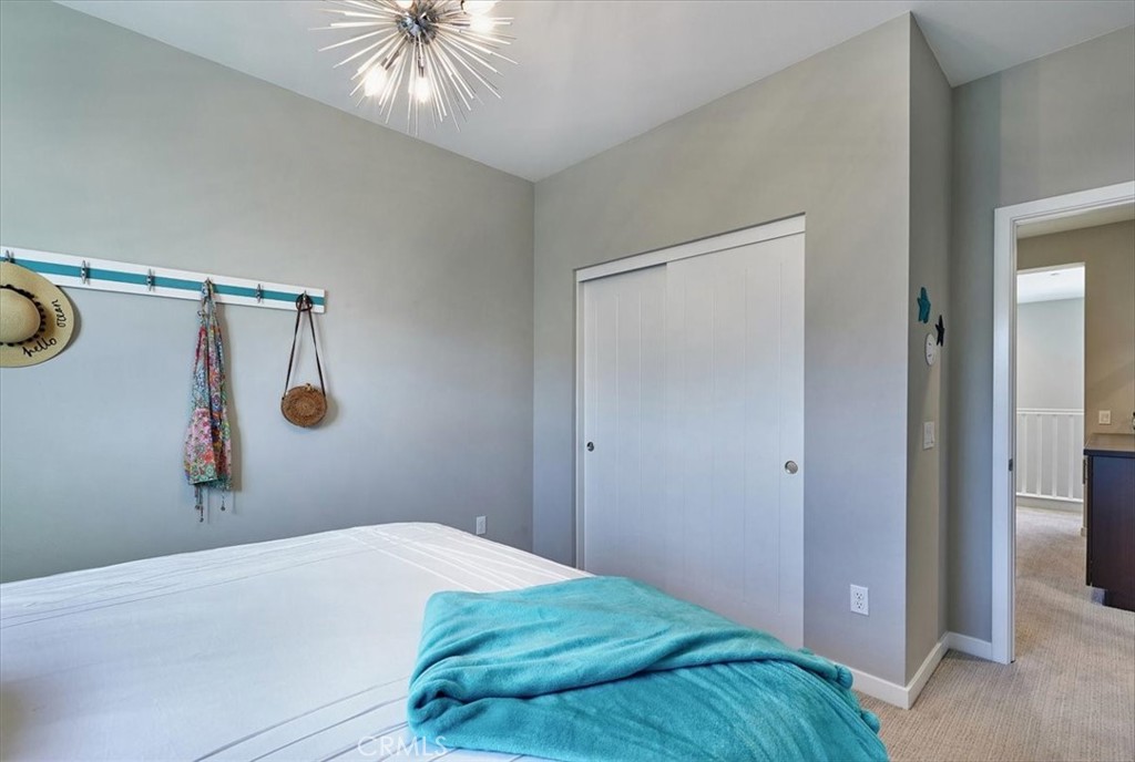 944 Sunlit Lane Costa Mesa, CA 92626 - Photo 47 of 71 a bedroom with a bed and a chandelier