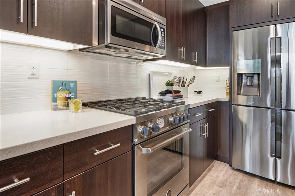 944 Sunlit Lane Costa Mesa, CA 92626 - Photo 10 of 71 a kitchen with stainless steel appliances granite countertop a sink stove and refrigerator