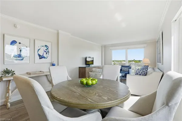 a living room with furniture a couch and a dining table with wooden floor