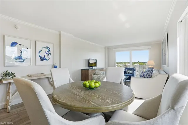 a living room with furniture a couch and a dining table with wooden floor