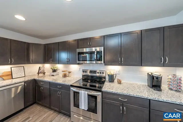 a kitchen with stainless steel appliances granite countertop a sink stove and cabinets