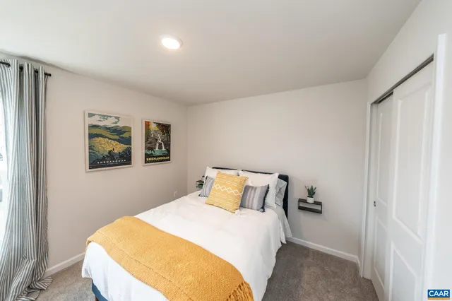 a bedroom with a bed and painting on the wall