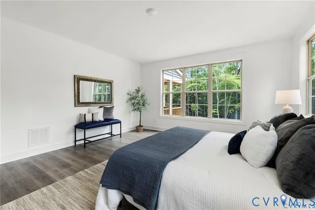 a bedroom with a bed a painting and a window