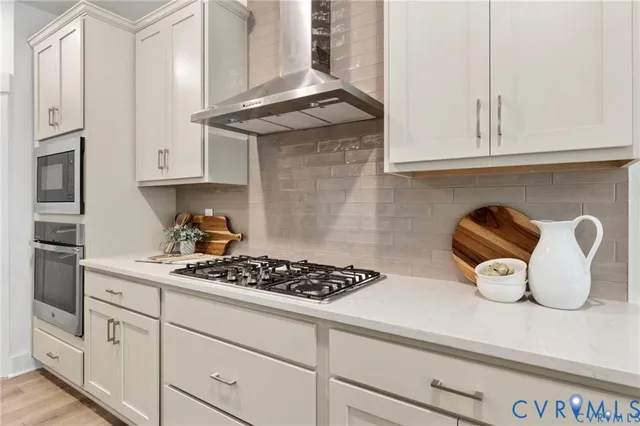 a kitchen with white cabinets and a stove