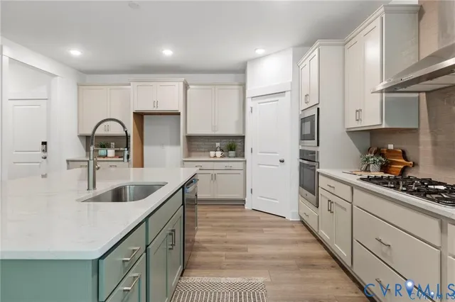 a kitchen with kitchen island granite countertop a sink stainless steel appliances and cabinets