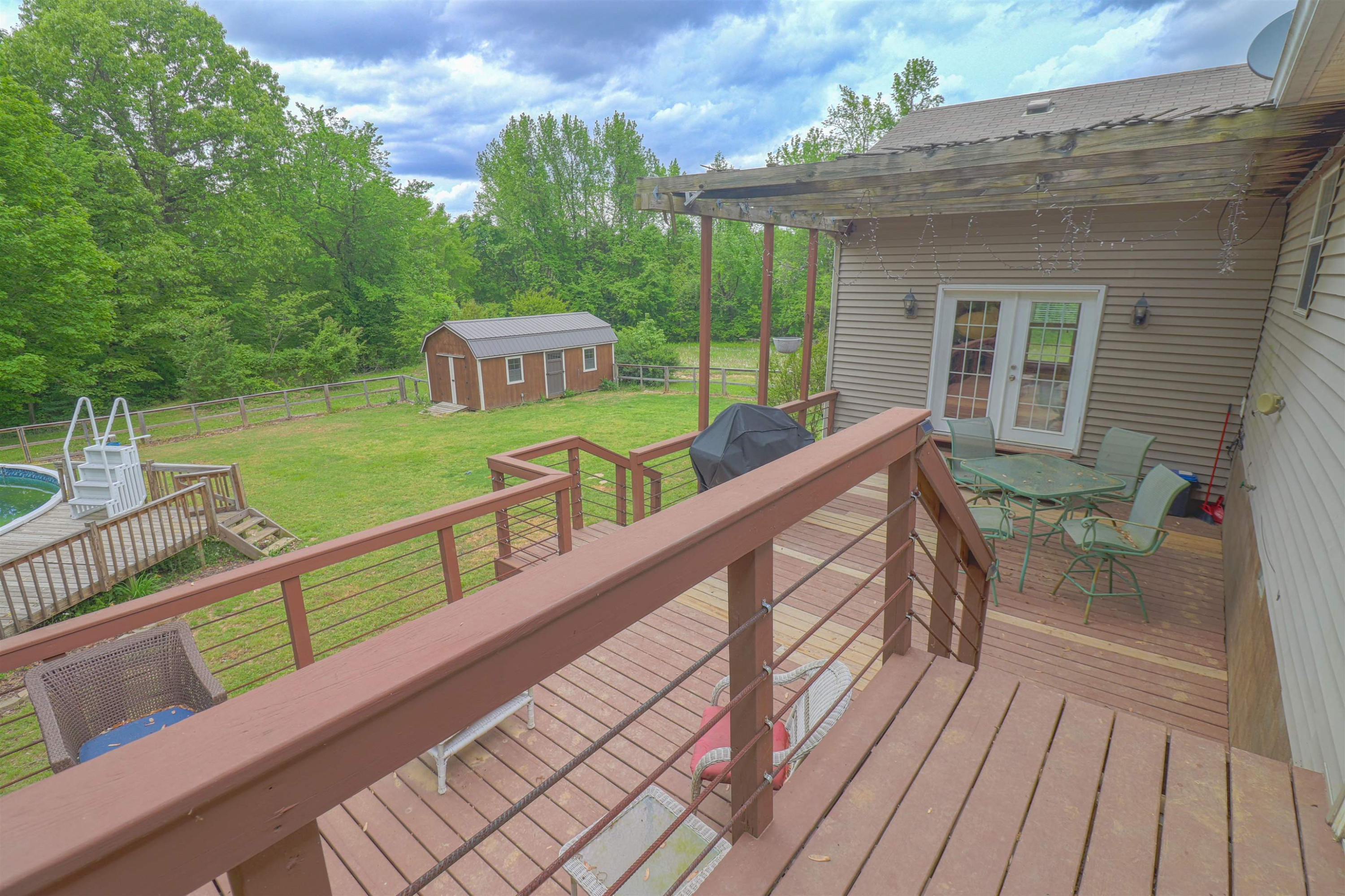 4934 Asbury Glimp Road Ripley, TN 38063 - Photo 19 of 25 a view of a deck with two chair and a floor to ceiling window