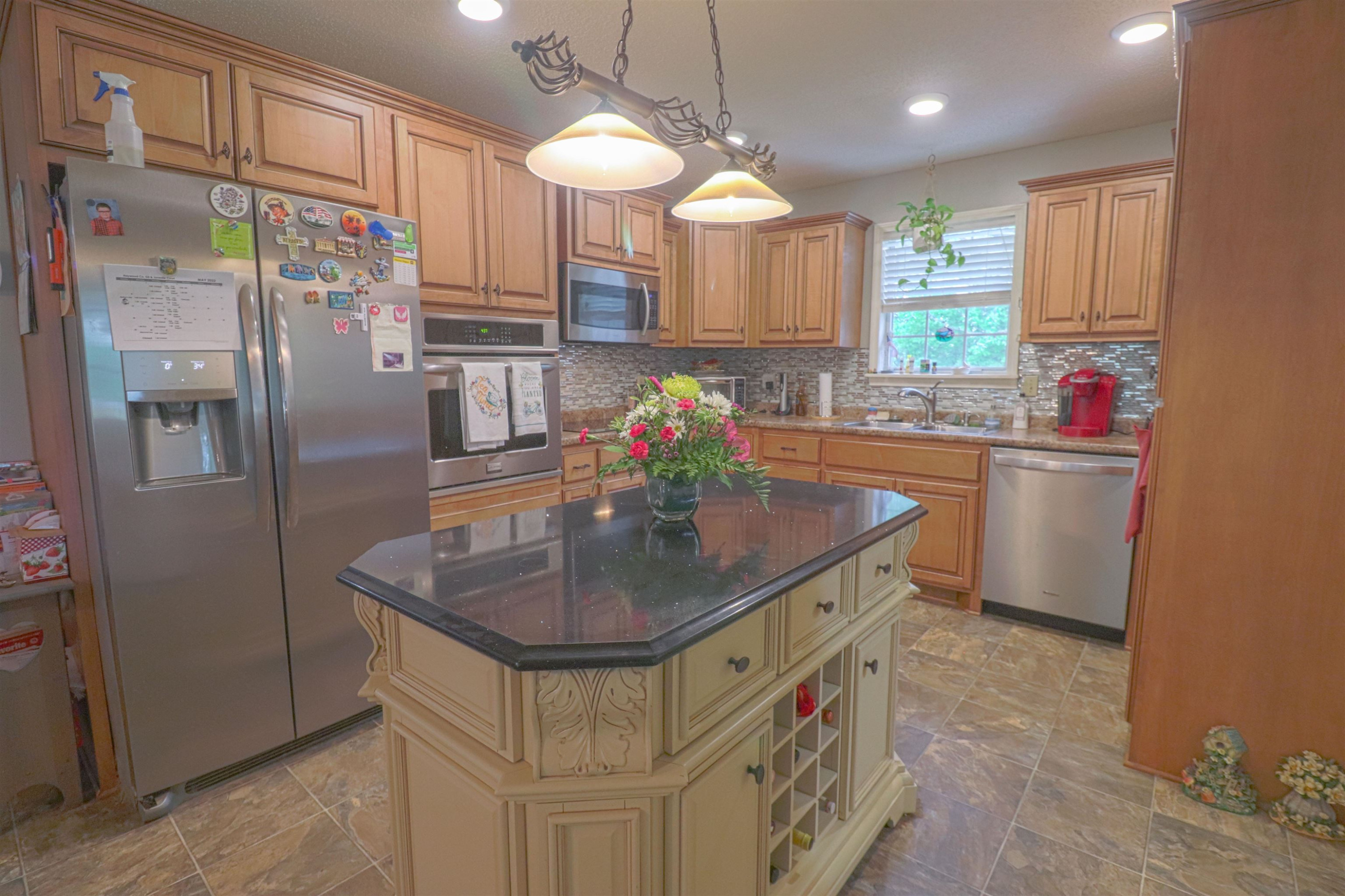 4934 Asbury Glimp Road Ripley, TN 38063 - Photo 6 of 25 a kitchen with stainless steel appliances granite countertop a sink a refrigerator and a wooden cabinets