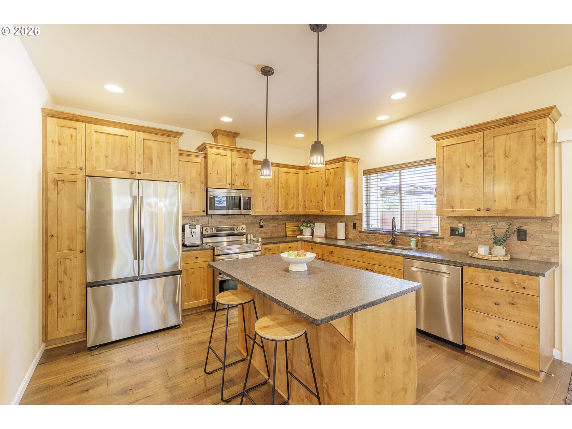 16802 Pony Express Way Bend, OR 97707 - Photo 9 of 37 a kitchen with stainless steel appliances granite countertop a refrigerator a sink dishwasher and a stove with wooden floor