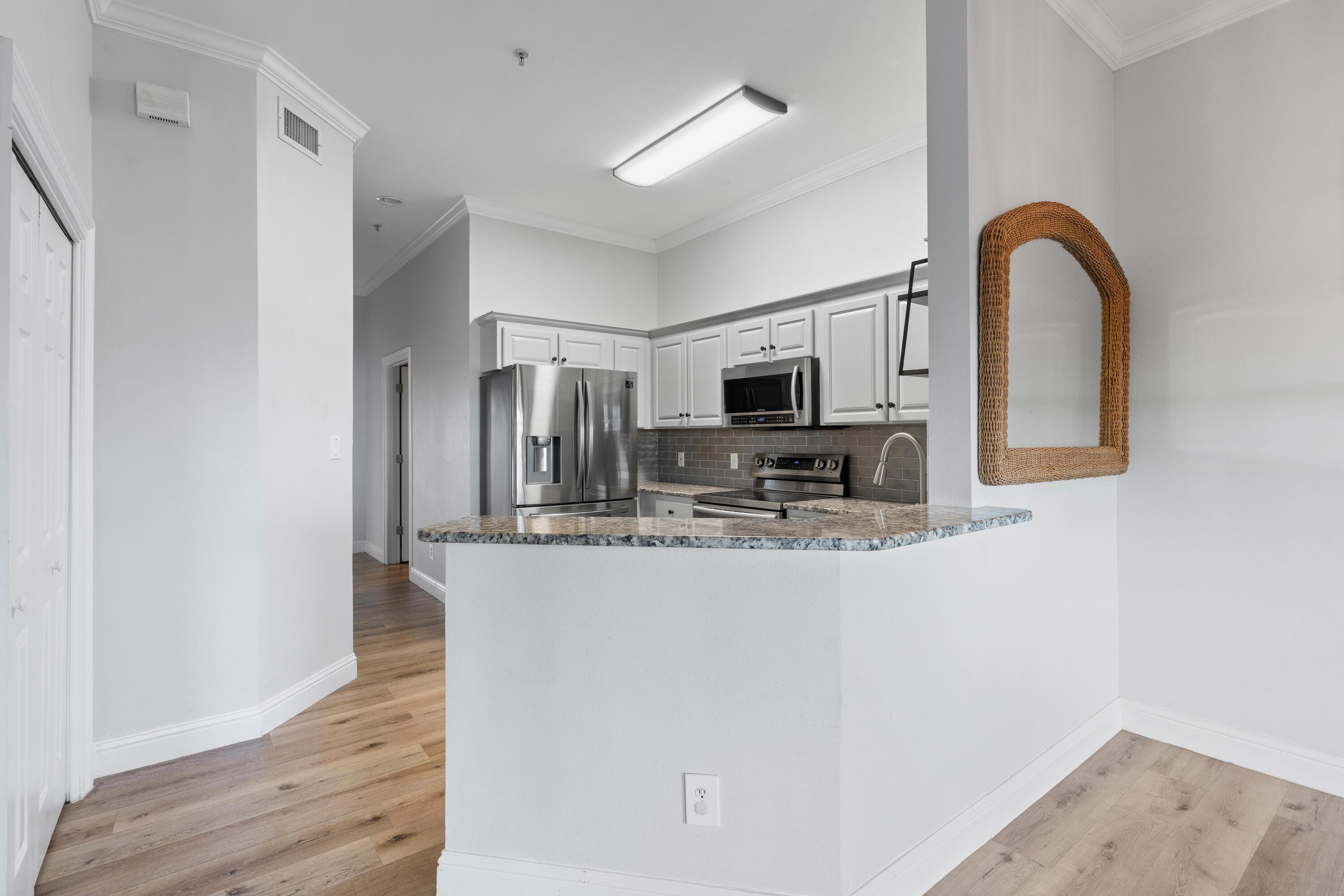 4507 Furling Lane, Unit 302 Destin, FL 32541 - Photo 16 of 49 a kitchen with stainless steel appliances granite countertop a refrigerator and a stove top oven
