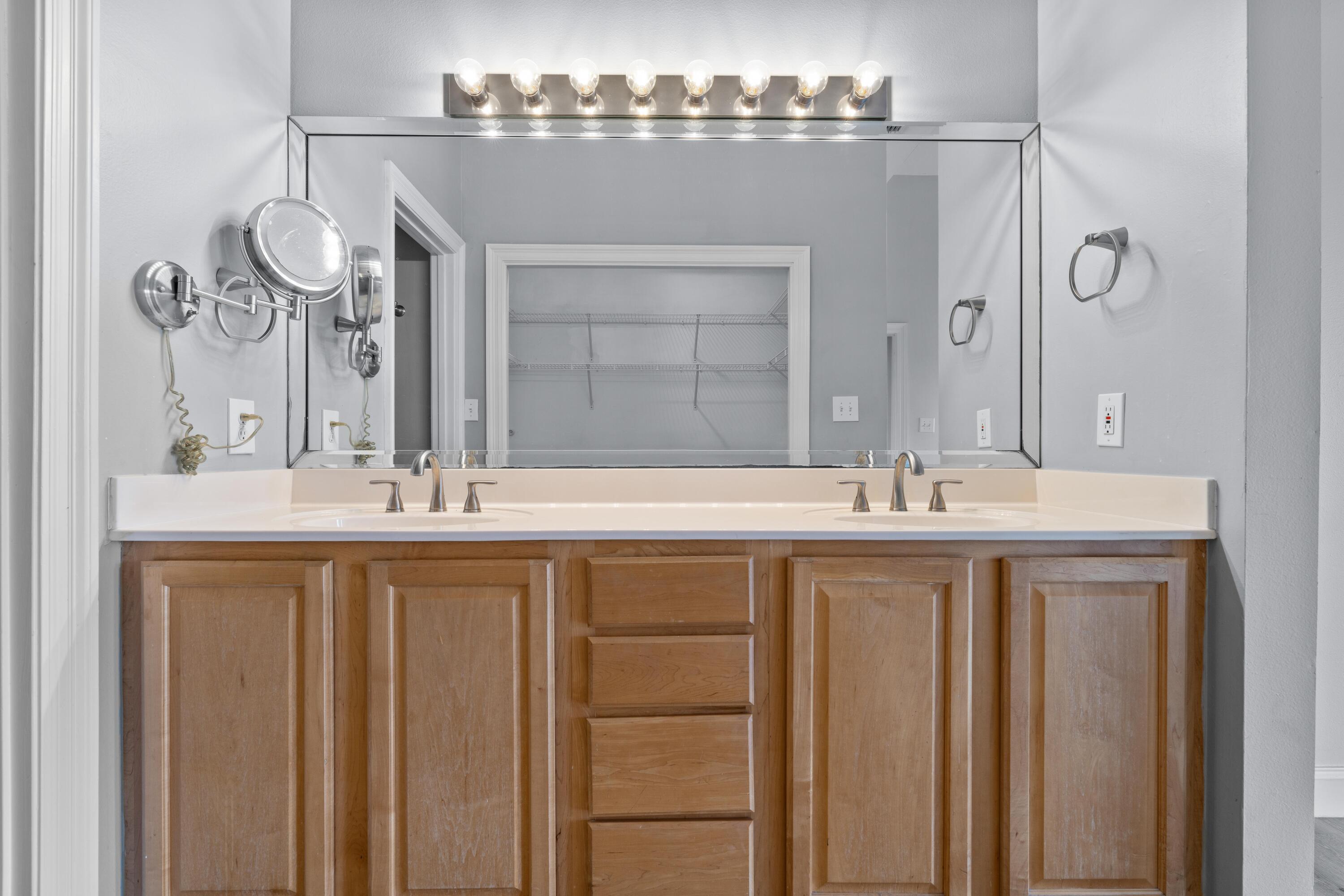 4507 Furling Lane, Unit 302 Destin, FL 32541 - Photo 27 of 49 a bathroom with a double vanity sink and a mirror