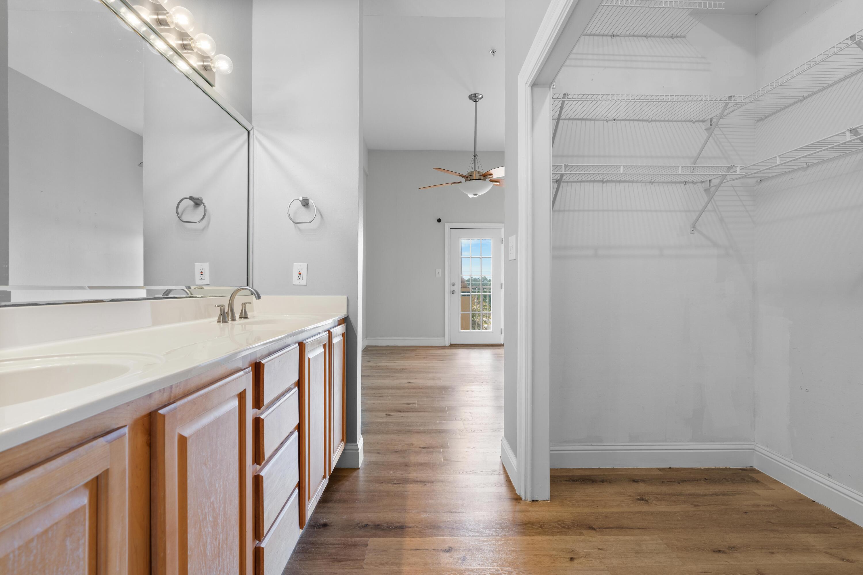 4507 Furling Lane, Unit 302 Destin, FL 32541 - Photo 30 of 49 a bathroom with a sink a mirror and shower