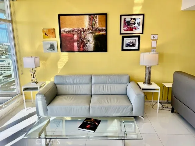 a living room with furniture and a painting on the wall