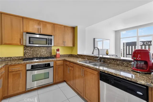 a kitchen with granite countertop a stove sink and microwave