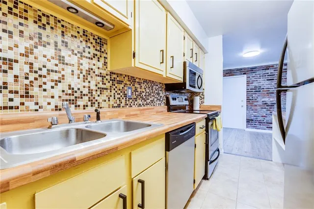 a kitchen with stainless steel appliances granite countertop a sink and a refrigerator