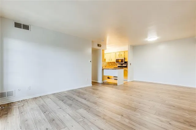 a view of a kitchen with a sink and wooden floor