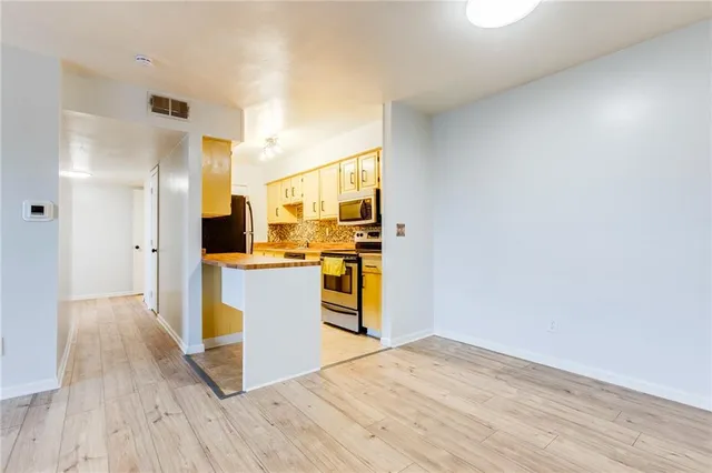 a kitchen with wooden floor and refrigerator