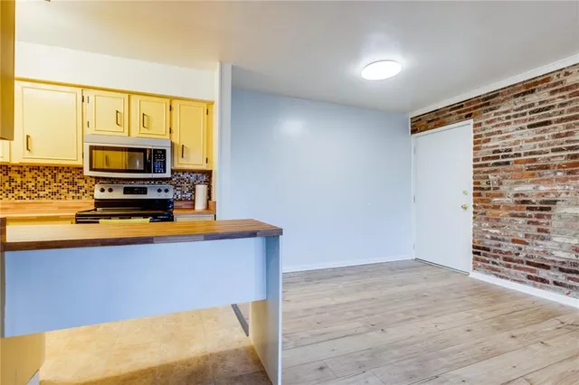 a kitchen with stainless steel appliances a stove top oven a sink and a microwave