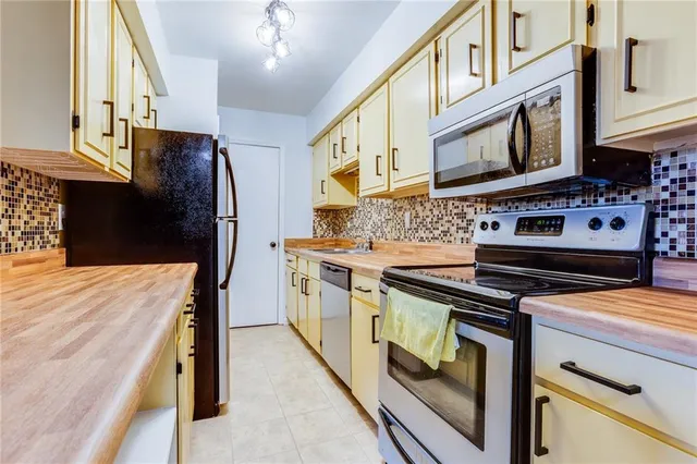 a kitchen with stainless steel appliances a stove microwave and a refrigerator