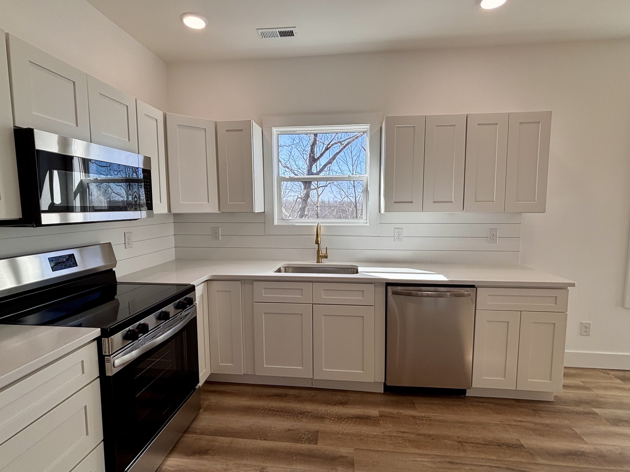 485 Baron Bluff Road Smithville, TN 37166 - Photo 12 of 28 a kitchen with stainless steel appliances white cabinets a sink and a stove