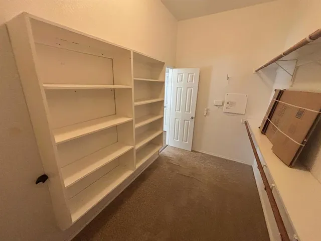 a view of walk in closet with empty racks