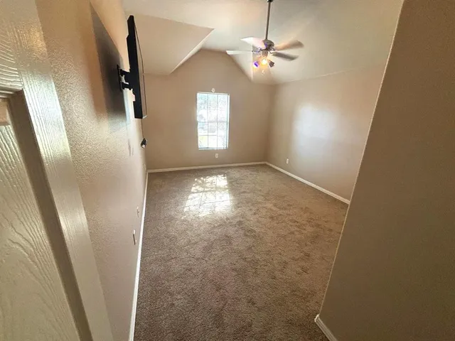 en empty room with window ceiling fan and window