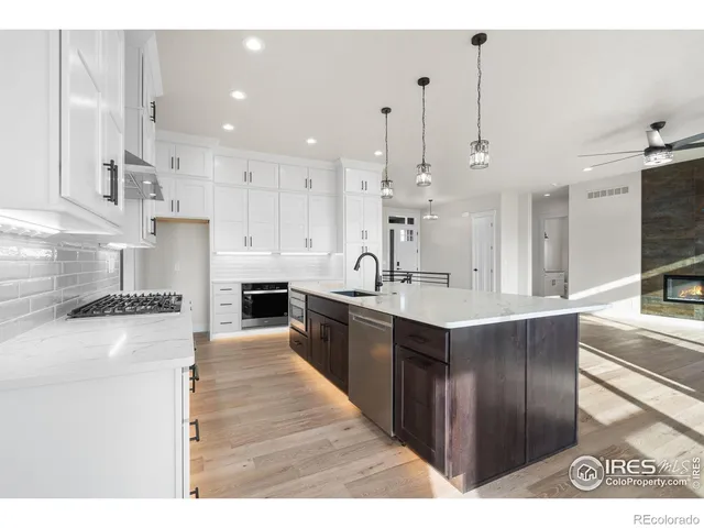 a kitchen with kitchen island granite countertop a sink counter top space and stainless steel appliances