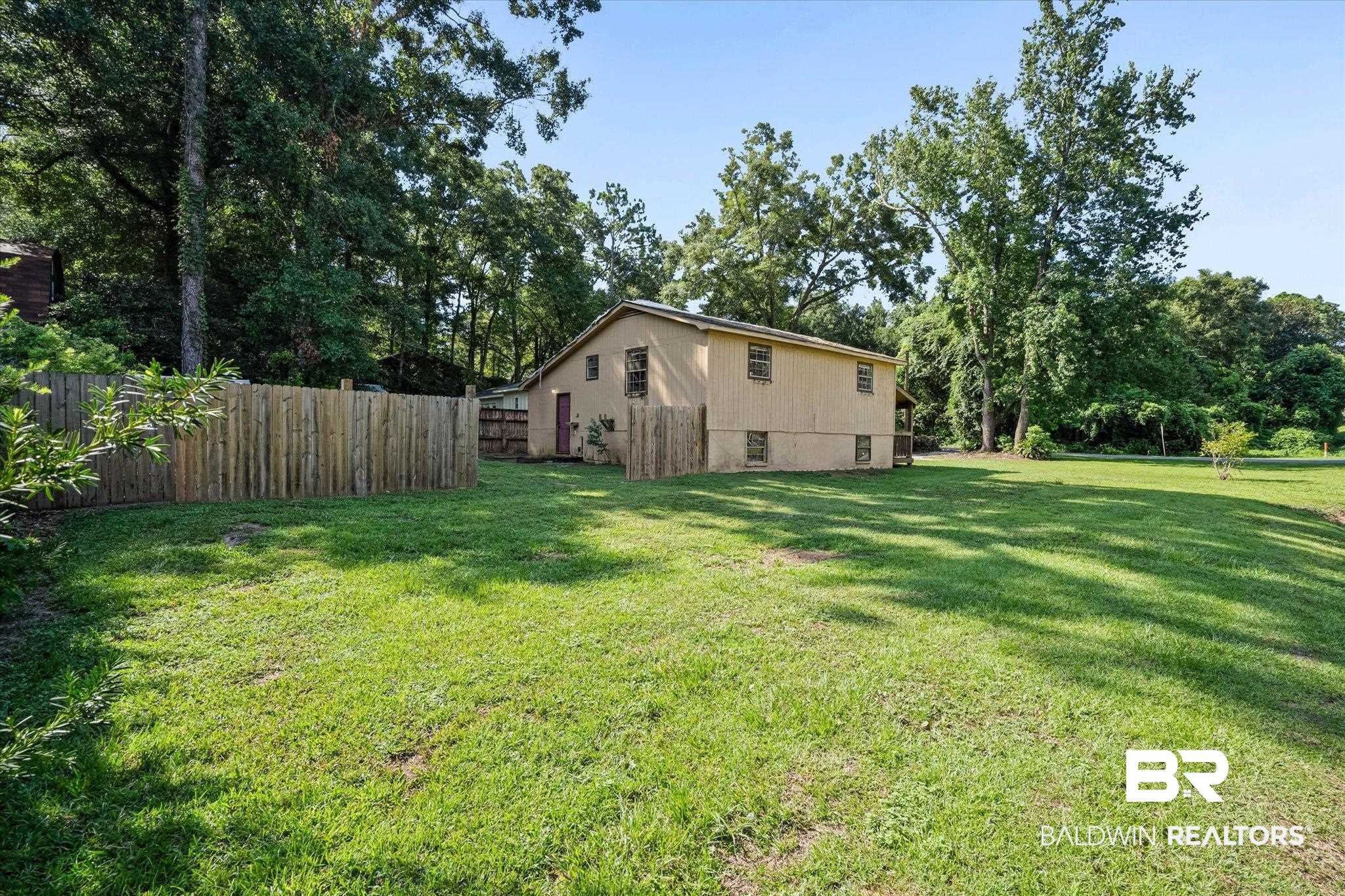 401 Frederick Avenue Fairhope, AL 36532 - Photo 21 of 36 Expansive green lawn surrounds the property, featuring a privacy fence along the perimeter