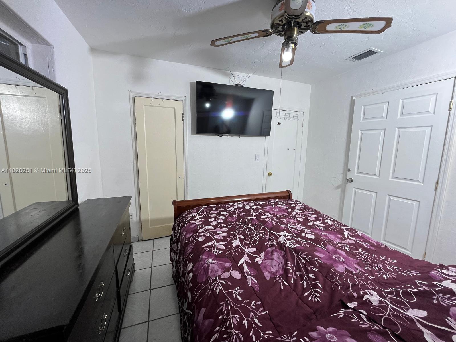 217 East 20th Street Hialeah, FL 33010 - Photo 16 of 22 a bedroom with a bed and a flat screen tv