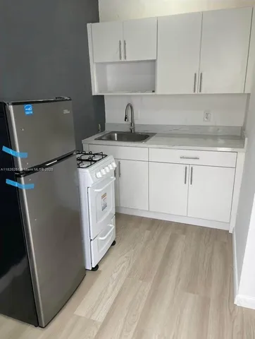 a kitchen with white cabinets and white appliances