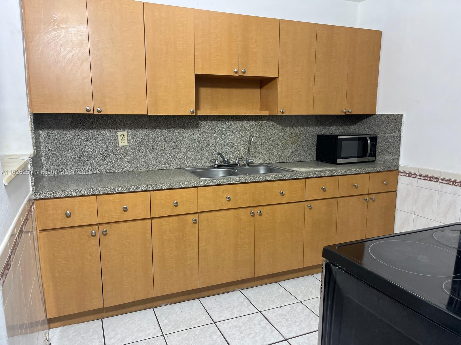 217 East 20th Street Hialeah, FL 33010 - Photo 2 of 22 a kitchen with granite countertop cabinets stainless steel appliances and a sink