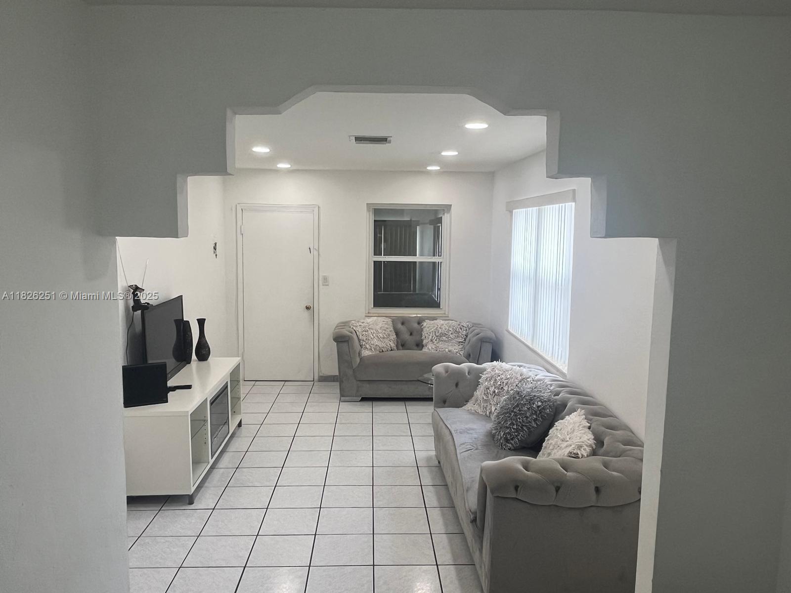 217 East 20th Street Hialeah, FL 33010 - Photo 4 of 22 a living room with furniture and a flat screen tv