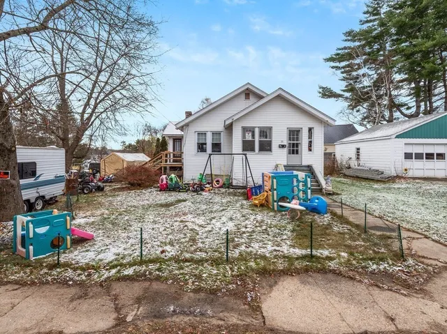 a view of a house with a yard covered in the forest