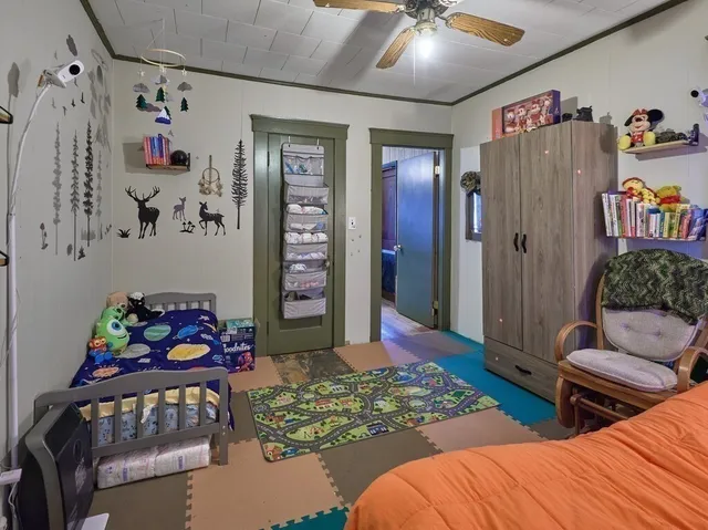 a bedroom with two beds and a baby crib