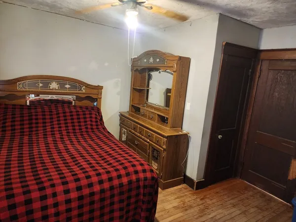 a bedroom with a bed and wooden floor