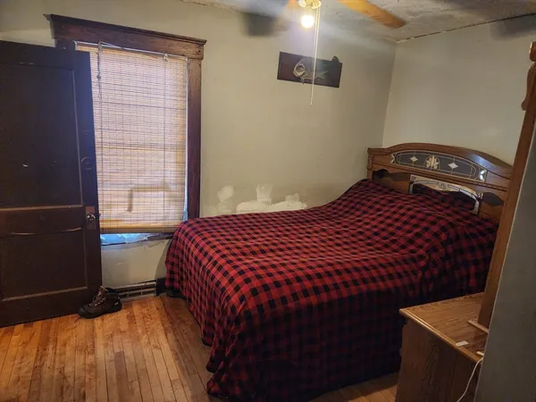 a bedroom with a bed and wooden floor