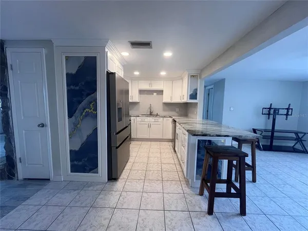 a kitchen with stainless steel appliances granite countertop a refrigerator and a stove top oven
