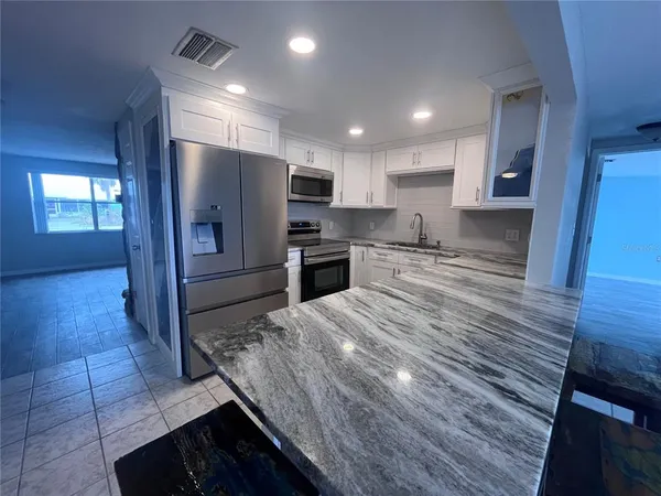 a kitchen with granite countertop stainless steel appliances a sink and counter space