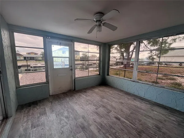 an empty room with wooden floor and windows