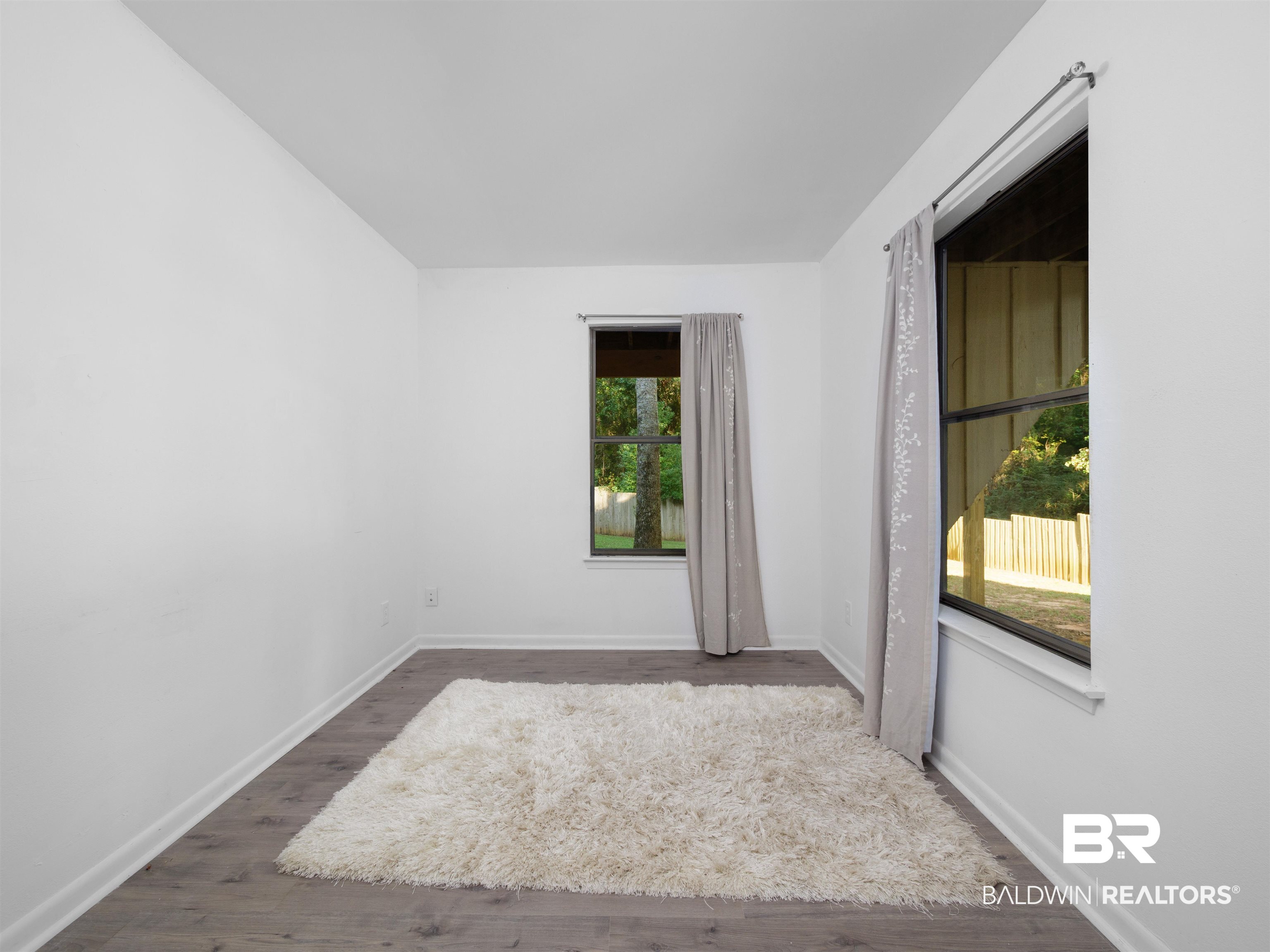 494 Ridgewood Drive Daphne, AL 36526 - Photo 20 of 40 Unfurnished room with dark hardwood / wood-style floors and a wealth of natural light