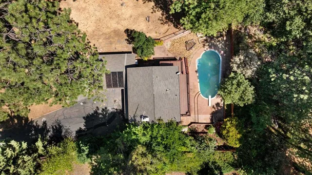 a large kitchen with stainless steel appliances a large counter top a sink and a chandelier