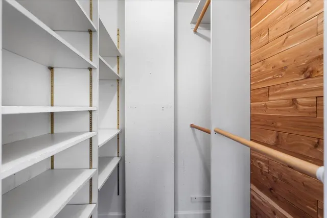 a view of a hallway with closet and a window