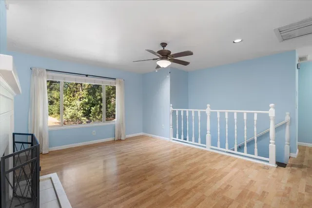 a view of an empty room with window and wooden floor
