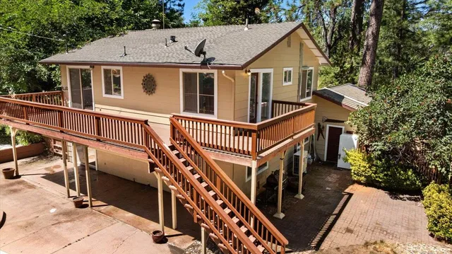 a view of a swimming pool with a patio and wooden fence