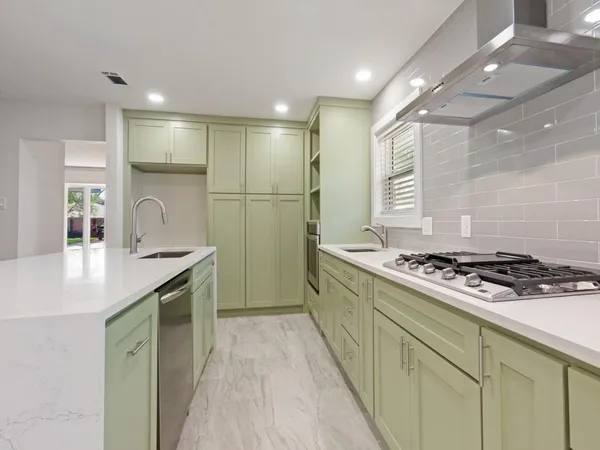 a kitchen with sink stove and cabinets