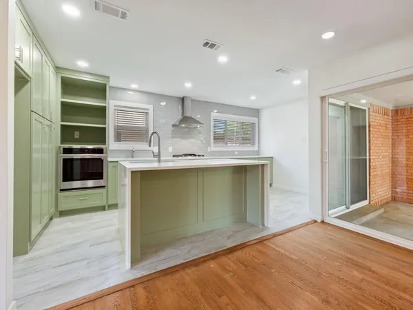 a kitchen with kitchen island a sink stainless steel appliances and cabinets