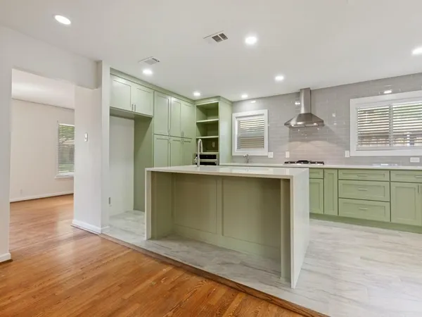 a kitchen with kitchen island a sink stainless steel appliances and cabinets