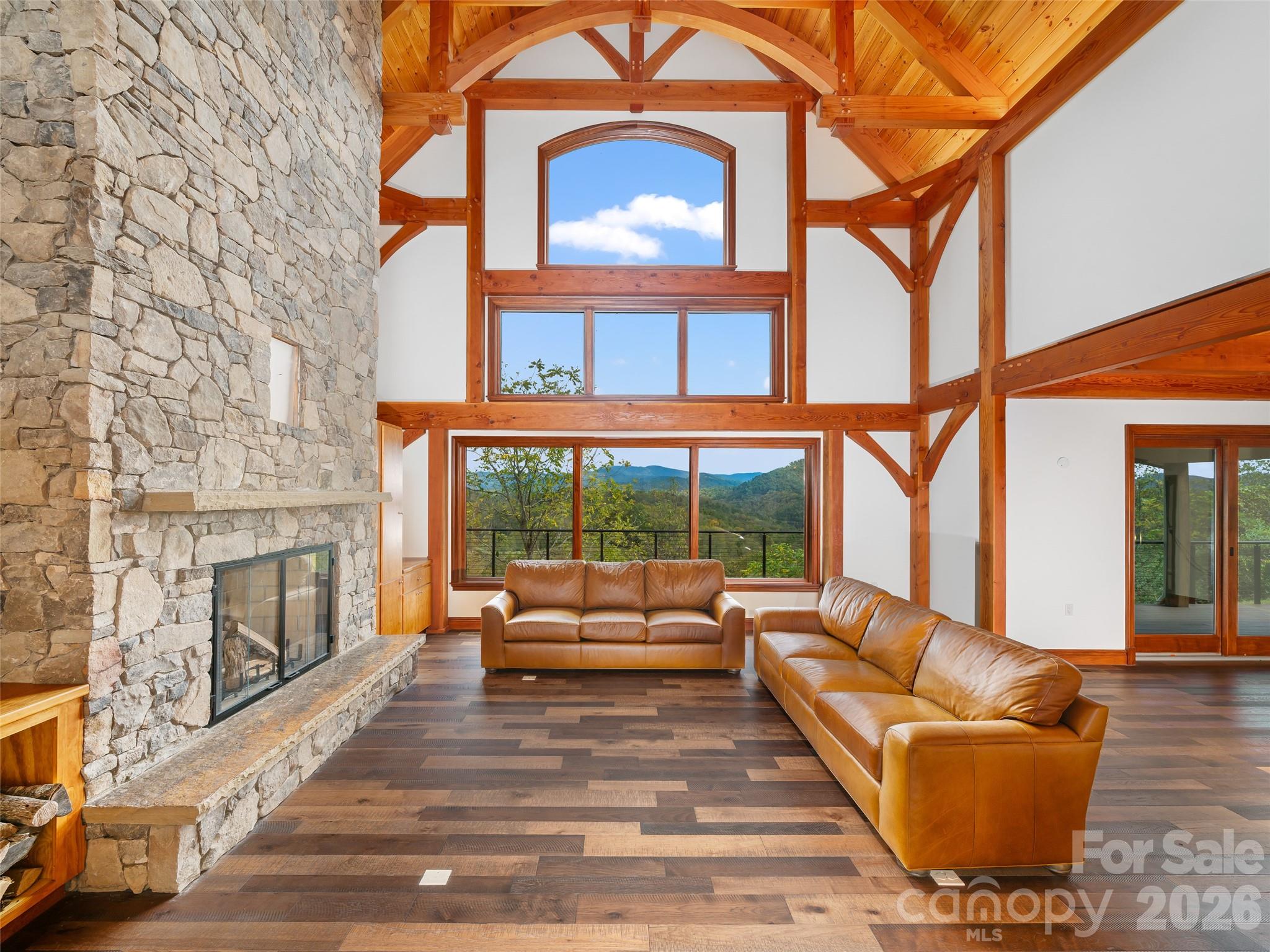 946 Ridge Road Green Mountain, NC 28740 - Photo 13 of 48 a living room with furniture a fireplace and floor to ceiling windows