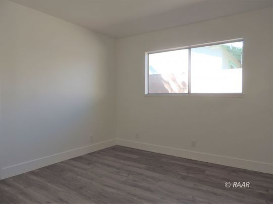 709 West Alene Avenue Ridgecrest, CA 93555 - Photo 11 of 20 an empty room with wooden floor and windows